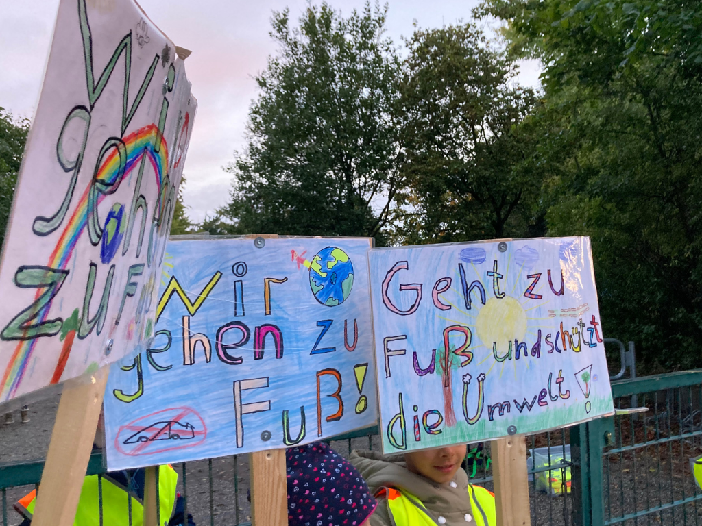 selbstgemalte Schilder mit dem Aufdruck "Wir kommen zu Fuß"